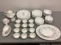 Front view of full set arranged on table showing cups, saucers, plates, bowls, teapot, sugar bowl, creamer, gravy boat, and platter