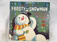 Front cover of Frosty The Snowman children's Christmas vinyl album, showing colorful illustration of Frosty the Snowman with a pipe and scarf.