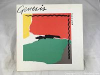 Front cover artwork of Genesis album ABCCAB showing abstract colorful artwork with black squiggly lines and title text.