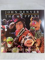 Front cover of 'A Christmas Together' album showing John Denver and Muppets characters in costumes with festive background.