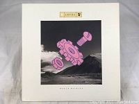 Front album cover of Level 42 World Machine showing the surreal mechanical parts artwork on landscape.