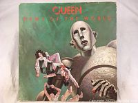 Front cover of Queen 'News of the World' vinyl album showing the iconic robot artwork with band members in its hand, background green.