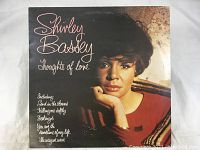 Front cover of the vinyl LP album 'Thoughts of Love' by Shirley Bassey showing portrait and song list.