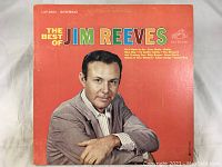 Front cover of The Best Of Jim Reeves vinyl LP record album featuring a photo of Jim Reeves and a red background.