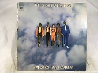 Front cover of The Chambers Brothers 'Love Peace and Happiness' album showing band members in colorful attire in sky background.