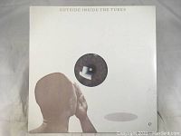 The front cover of 'Outside Inside' by The Tubes shows a side profile of a head and a white pipe circular image, mostly white with embossed title text.