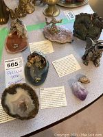 Photo showing multiple agate and geode sculptures on a table, including polished and natural stone pieces