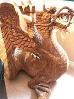 Full view of carved wood dragon base showing body posture and carved scales