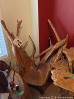 Overall angled view of teak root chair showing irregular shape and protrusions