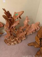 Full frontal view of sculpture showing entire group of fish and base