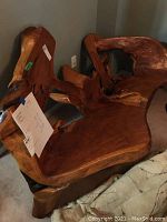 Front angle of teak bench showing seat and backrest carved from a single piece of wood