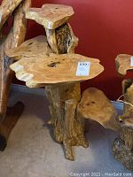 Front angle showing multiple natural wood shelves and the textured trunk base.