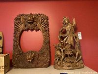 Both mirror frame and sculpture side by side against red background