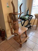 Front angled view of teak wood display stand showing four tiers and rustic design