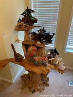 Overall view of burl wood shelving stand with decorative items on tiers