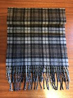 Folded scarf showing length, fringe, and plaid pattern.
