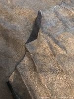 Close-up showing the gold metallic finish and soft texture of one leather hide.