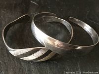 Oblique view of both open cuff bracelets overlapping