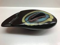 Top view of the oval lidded vessel showing the abstract colored glaze and handle on the lid.