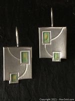 Front view of both sterling silver rectangular earrings showing swirling indented line and green enamel squares.