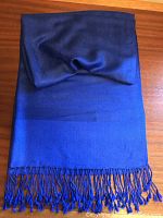 Folded view of the scarf showing overall blue/violet color and fringe on one end.
