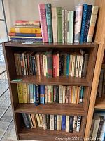 Full bookshelf containing multiple rows of assorted books including novels, reference, and history.