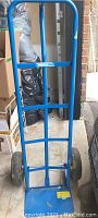 Full view of the blue Mastercraft hand truck dolly showing frame and rubber wheels.