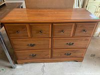 Front view of wooden dresser showing six drawers and hardware.