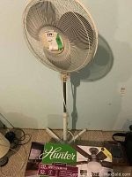 Windmere standing fan front view showing white wire grill and three-legged base.