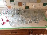 Full set of mixed glassware including various beer glasses, wine glasses, and whiskey glasses displayed on a kitchen counter.