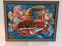 Front view of the abstract oil painting in a wooden frame showing the artwork's colors and design.