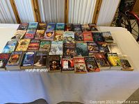 Wide view of entire collection of books on a table, showing all titles and cover art.