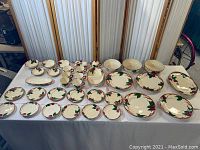 Full set of Franciscan Ware Apple pattern dishware displayed on table including plates, bowls, cups, saucers, and serving platters.