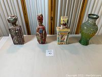 Full view of four handmade mosaic bottles and vase on table
