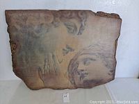 Front view of Italian style architectural wall art showing detailed graphics of two classical faces, with a faux concrete resin texture.