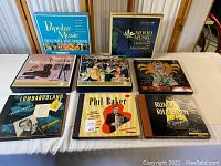 Overview of 8 vintage record albums on a table showing various artists and collections.