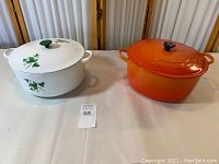 Both Dutch ovens side by side on table, showing size and color difference