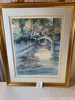 Full view of framed signed lithograph print 'Morning Magic' by Diane Clapp Bartz portraying a scenic watercolor landscape with a stone bridge over water and trees.