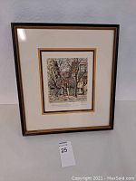 Framed vintage colored print showing the full piece including double mat with gold and white colors, dominant image shows a building with trees.