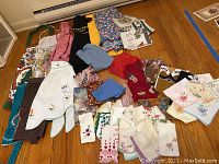 Overview of all aprons, handkerchiefs, scarves, and tea towels laid out on floor