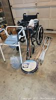 Overall lot view showing wheelchair, commode, canes, crutches, and medical supplies
