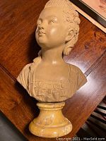 Three-quarter view of terracotta bust showing head, shoulders, and round marble base