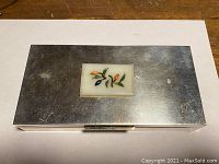Top view of rectangular silver exterior with inset jade plaque and minor surface scratches