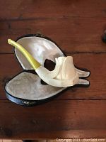 Antique carved white pipe with yellow amber stem in opened fitted black case on wooden surface.