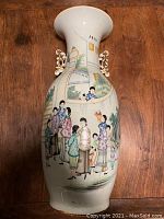 Front full view of vase showing figural decoration on body and applied handles
