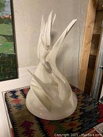 Front view of white porcelain bird sculpture on patterned surface