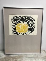 Framed full artwork showing black stylized birds around a yellow sun motif, within a matte and metal frame.