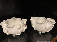 Front view of both bowls on shelf showing overall shape and applied decorations