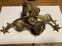 Both bronze spurs piled together showing overall design and wear