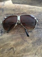 Front view of vintage Jaguar sunglasses showing brown lenses and gold frames with Jaguar logo on lens